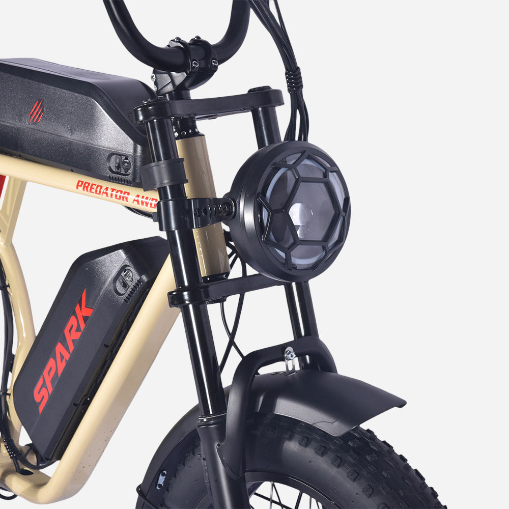 Кругла передня фара із захисною решіткою та амортизаційна вилка SPARK PREDATOR AWD, крупний план.